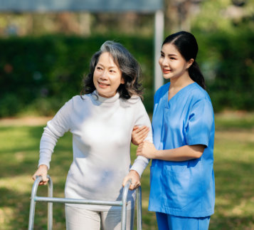 Caregiver and elderly woman having a stroll outdoor