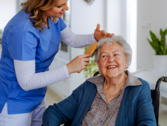Caregiver combing the hair of the elderly woman
